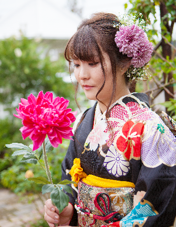 花を持つ振袖の女性